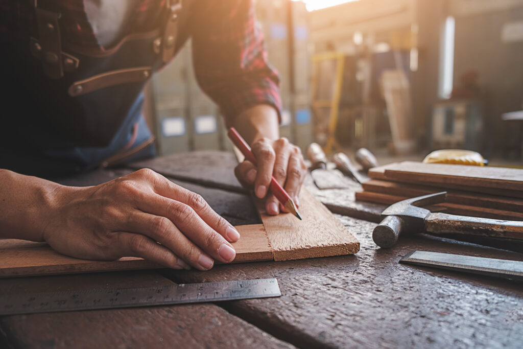 Carpenter working with equipment on wooden table in carpentry shop. woman works in a carpentry shop.